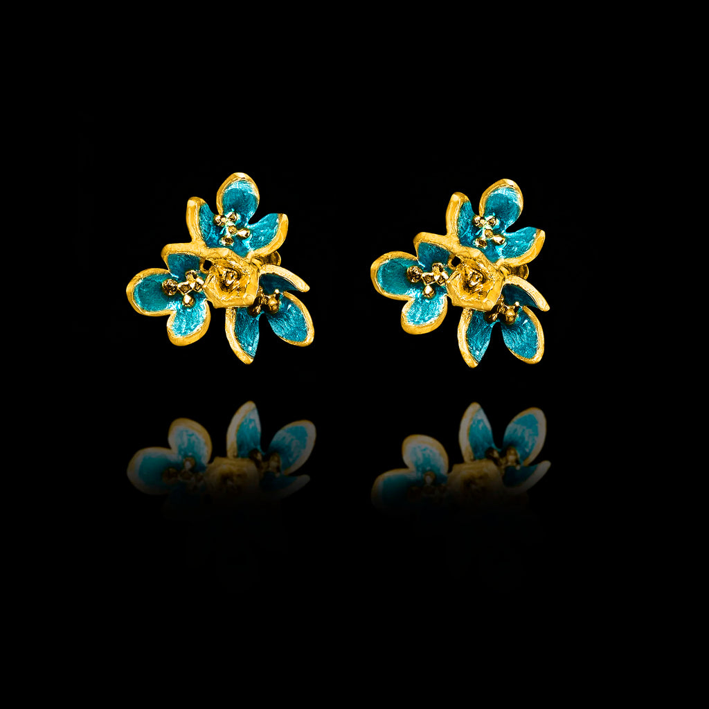 Front view of gold flower stud earrings with layered petals and vibrant turquoise enamel detailing.