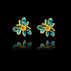 Front view of gold flower stud earrings with layered petals and vibrant turquoise enamel detailing.
