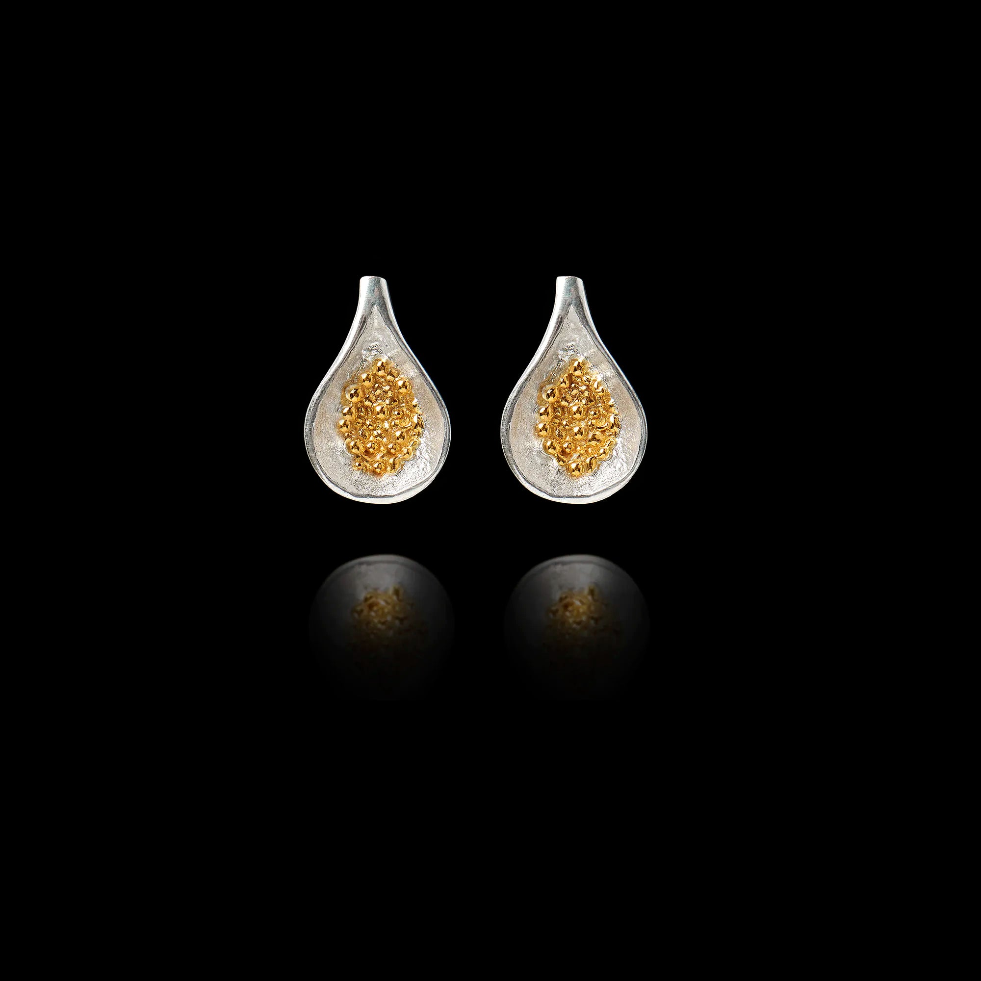 Front view of fig stud earrings with a silver shell and a gold seed cluster centre.