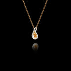 Side angle view of a 925 sterling silver fig pendant showing the smooth rhodium-plated teardrop form and gold-plated granule seed cluster on a gold chain against a black background.