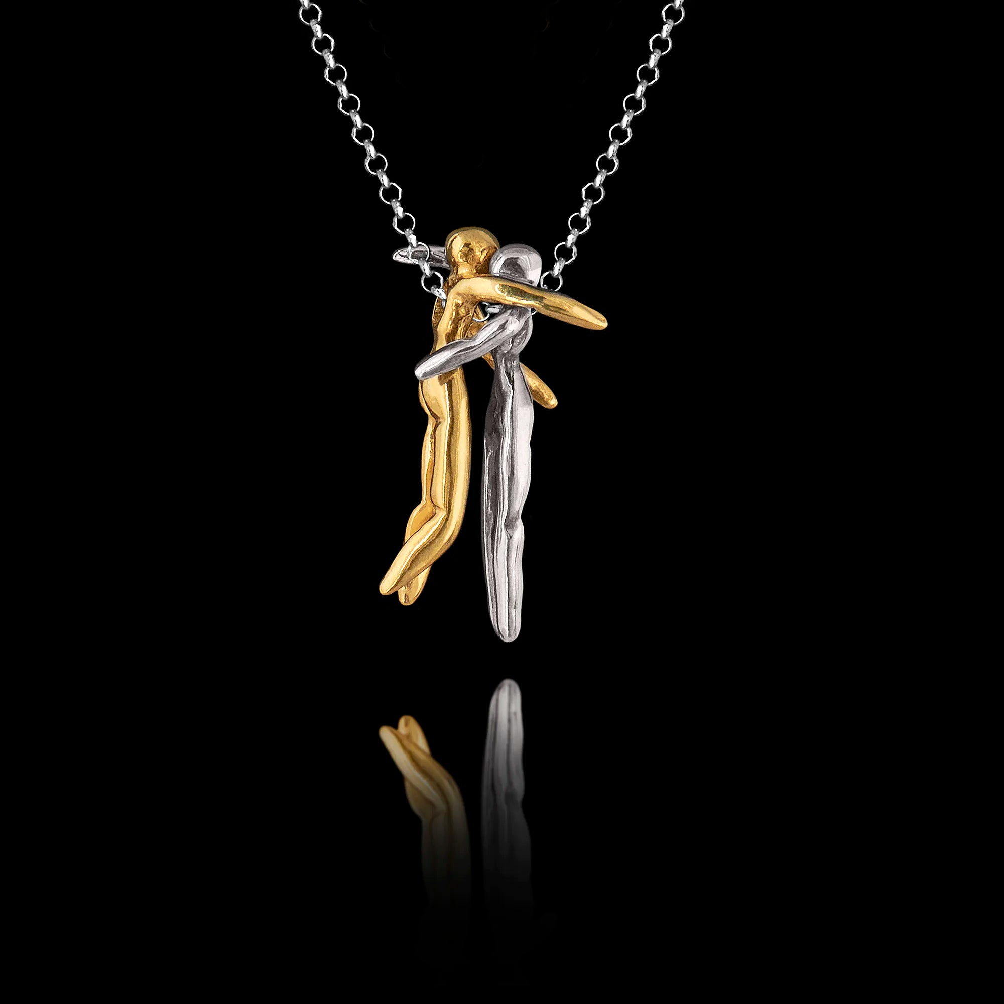  925 sterling silver hug pendant featuring two sculpted figures in a tender embrace — one gold-plated — linked by a small chain, hanging on a silver chain against a black background.