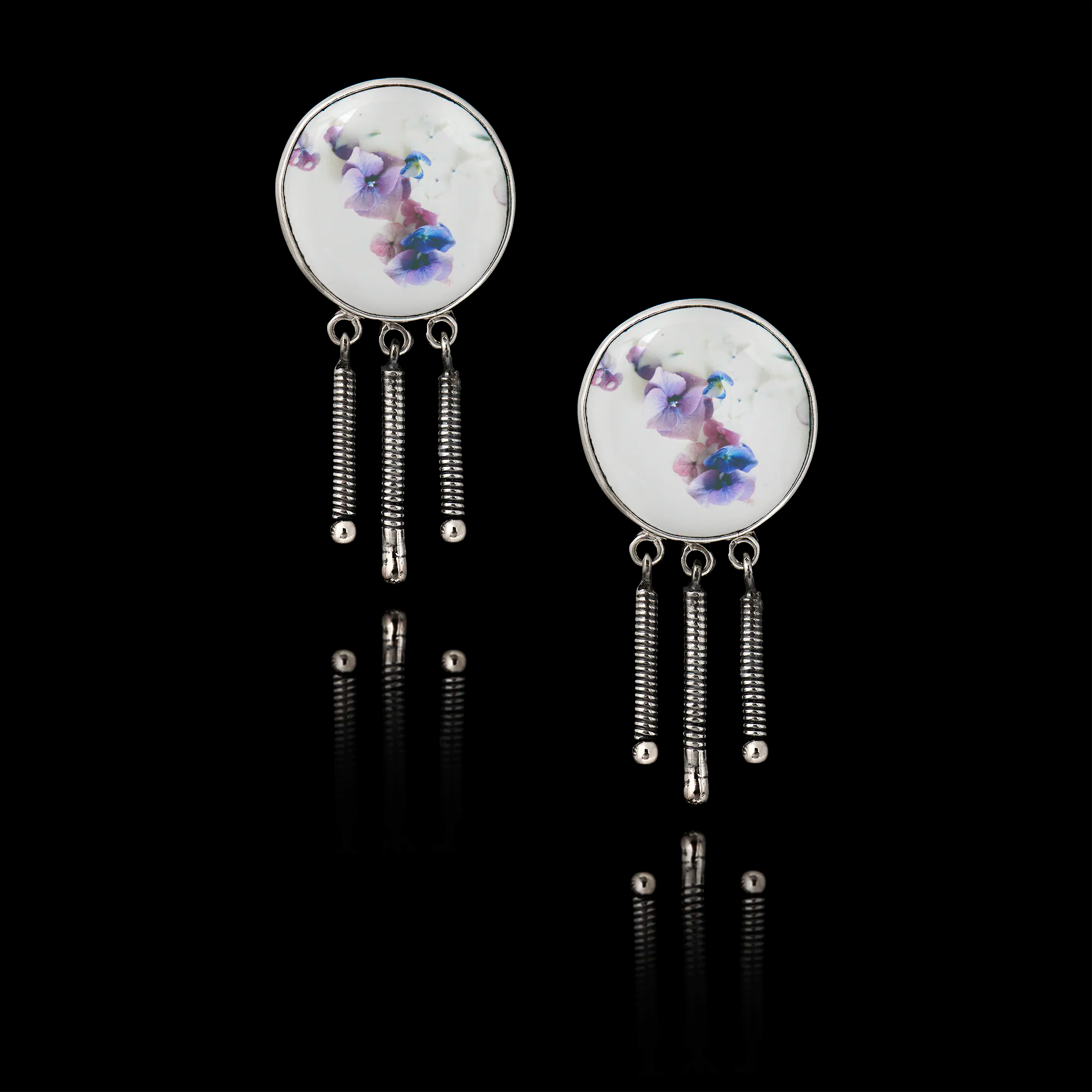 Pair of earrings with floral design on a black background