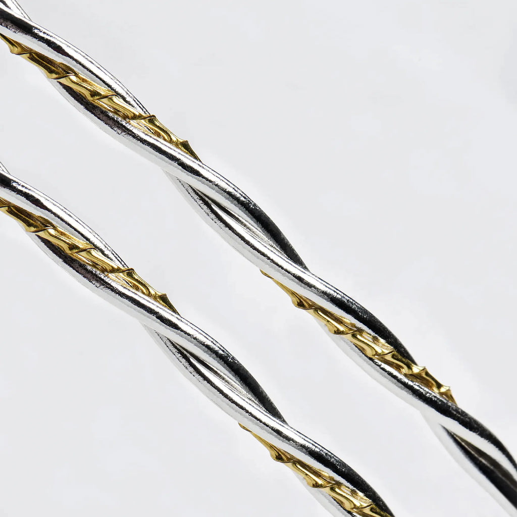Close-up detail of twisted round sterling silver wires intertwined with a textured twisted gold-plated wire.