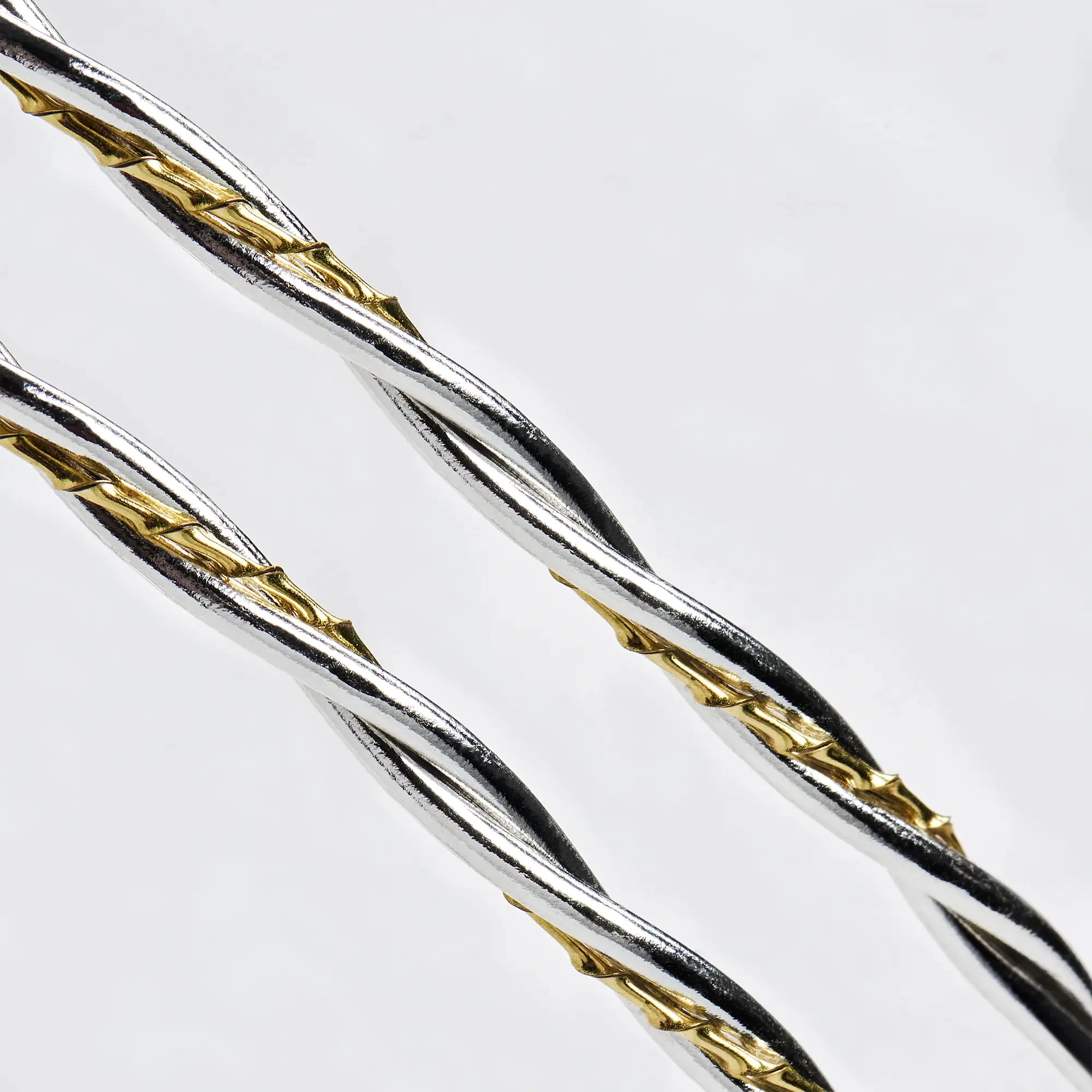Close-up detail of twisted round sterling silver wires intertwined with a textured twisted gold-plated wire.