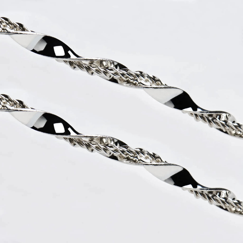 Close-up detail of sterling silver wedding crowns featuring a wide, polished twisted ribbon intertwined with a fine textured wire.