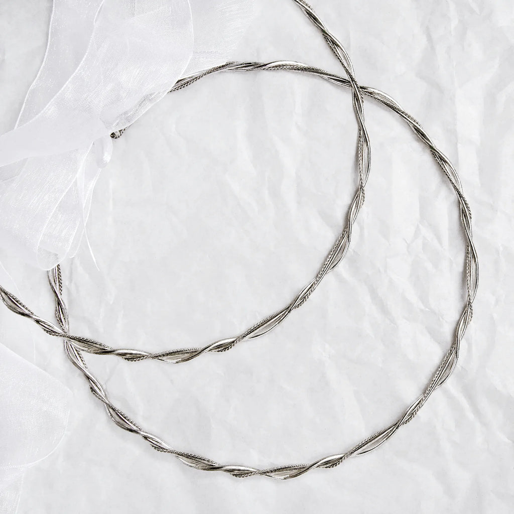 Full view of handmade braided silver wedding crowns featuring thick round wires and intricate twisted details.