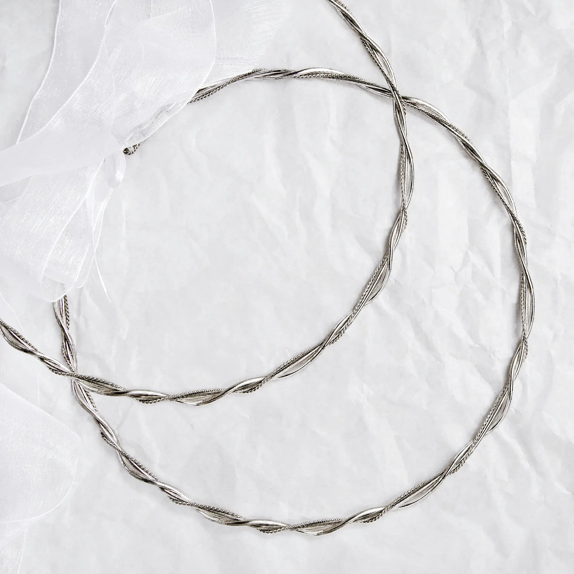 Full view of handmade braided silver wedding crowns featuring thick round wires and intricate twisted details.