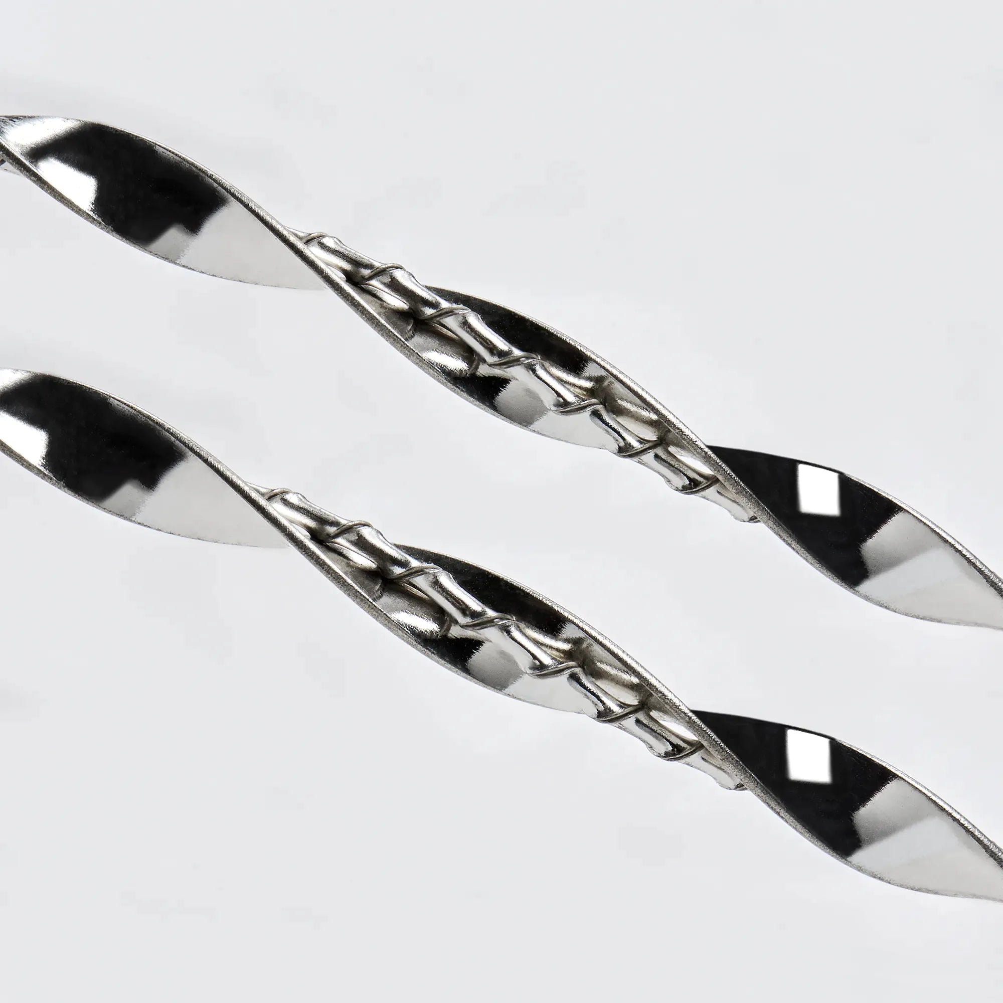 Close-up detail of the intricate dual-twisted sterling silver design, showing the play of light on the silver ribbon.