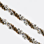 Close-up of sterling silver wedding crowns featuring lustrous gold pearls and brilliant multicolored crystals.