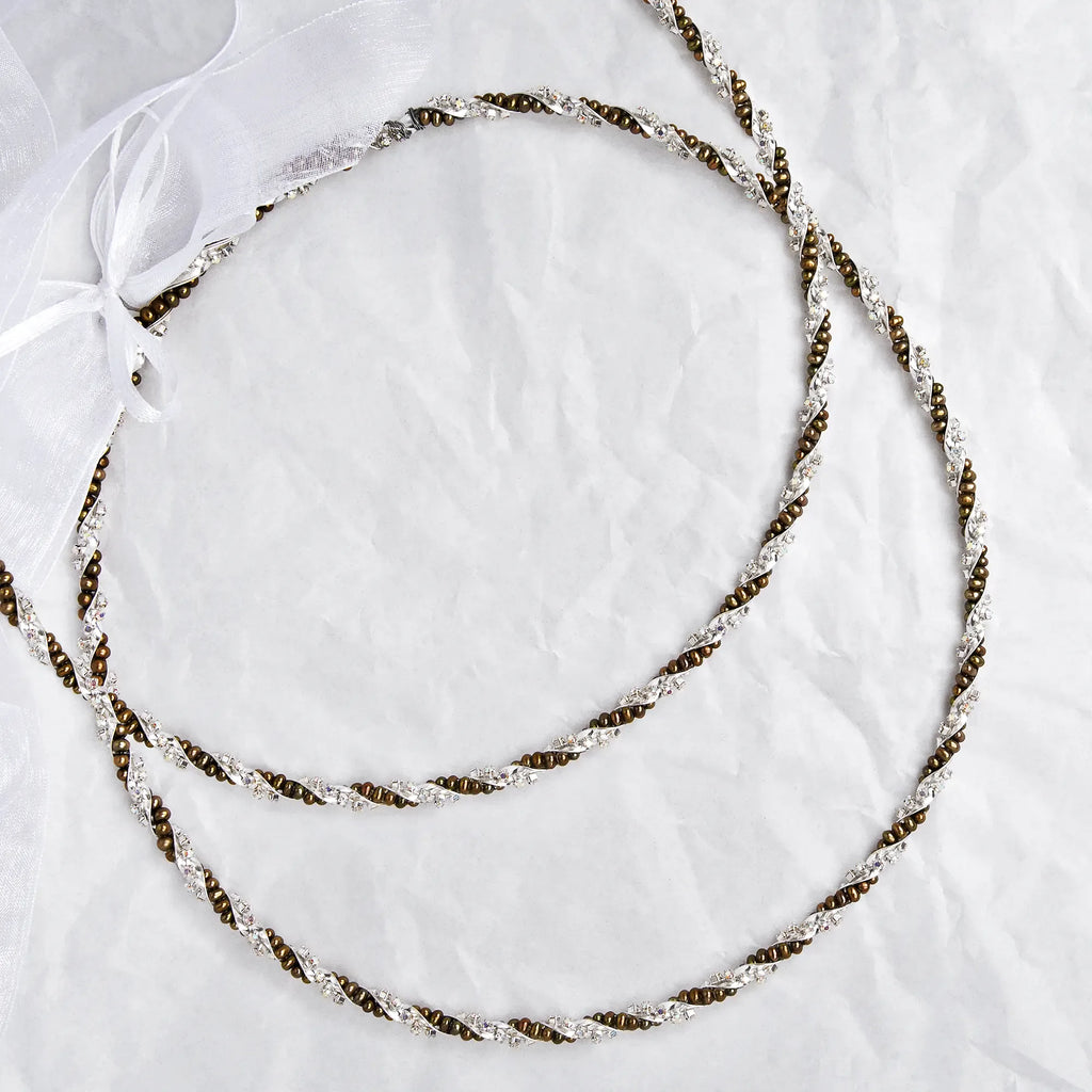 Full view of handmade sterling silver Stefana with gold-toned pearls and colorful crystals on a white textured background.